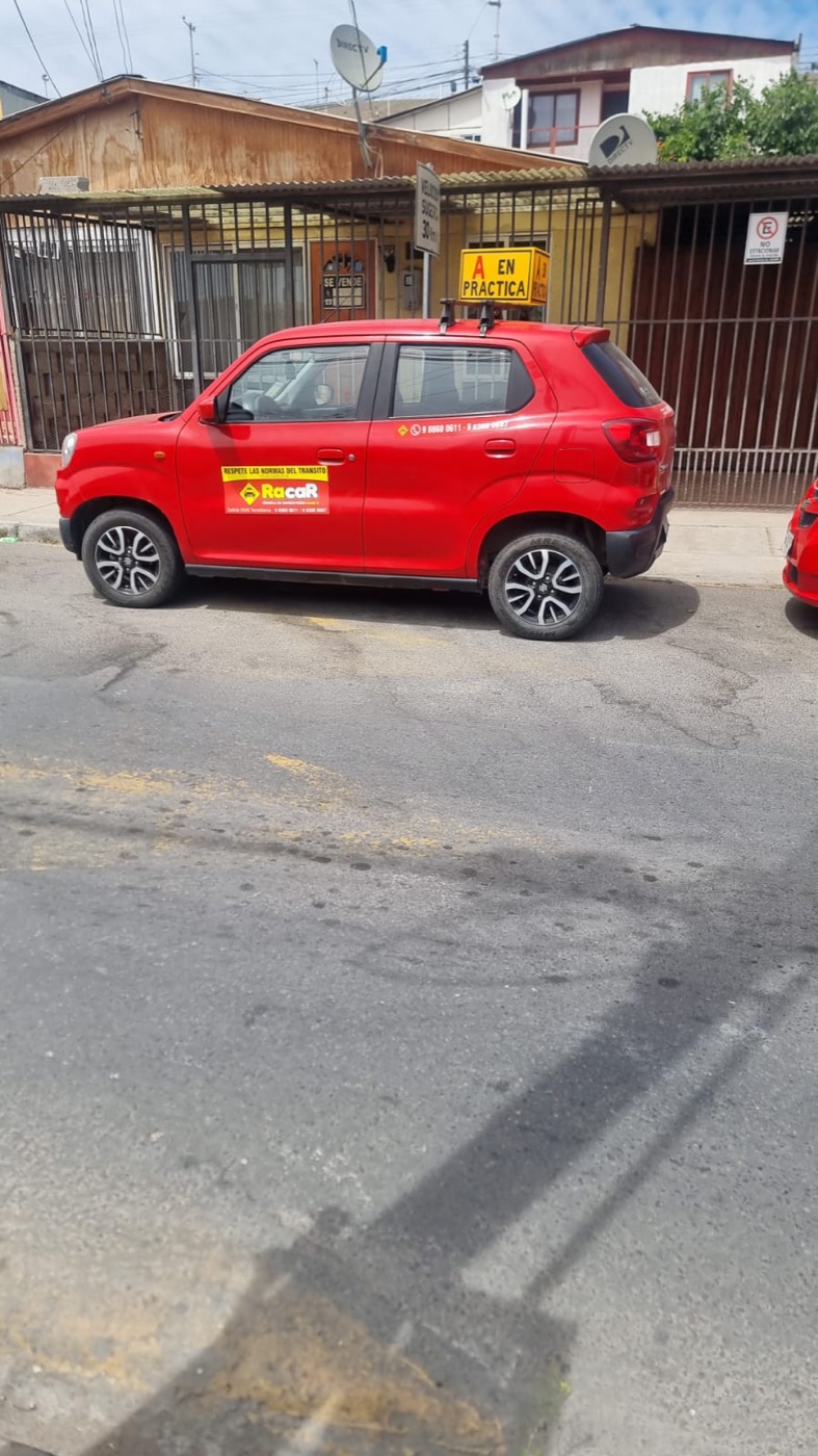 Auto rojo de RacaR con el cartel A en práctica estacionado en una calle de Vallenar